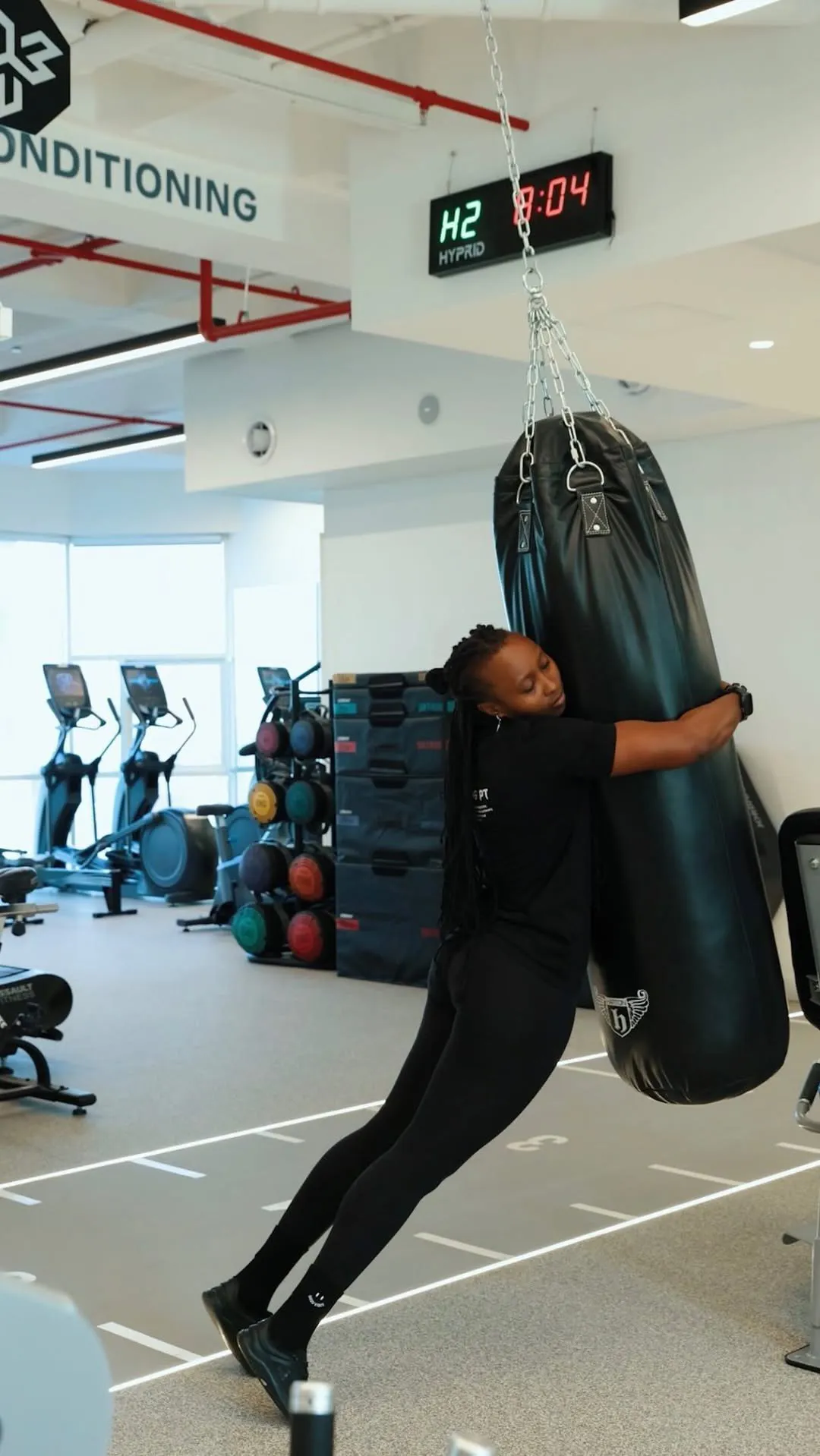 A member trains with a hanging punching bag in the conditioning zone at The OG
