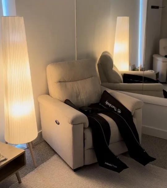The leg recovery room with a reclining chair, compression boots and tall lamps